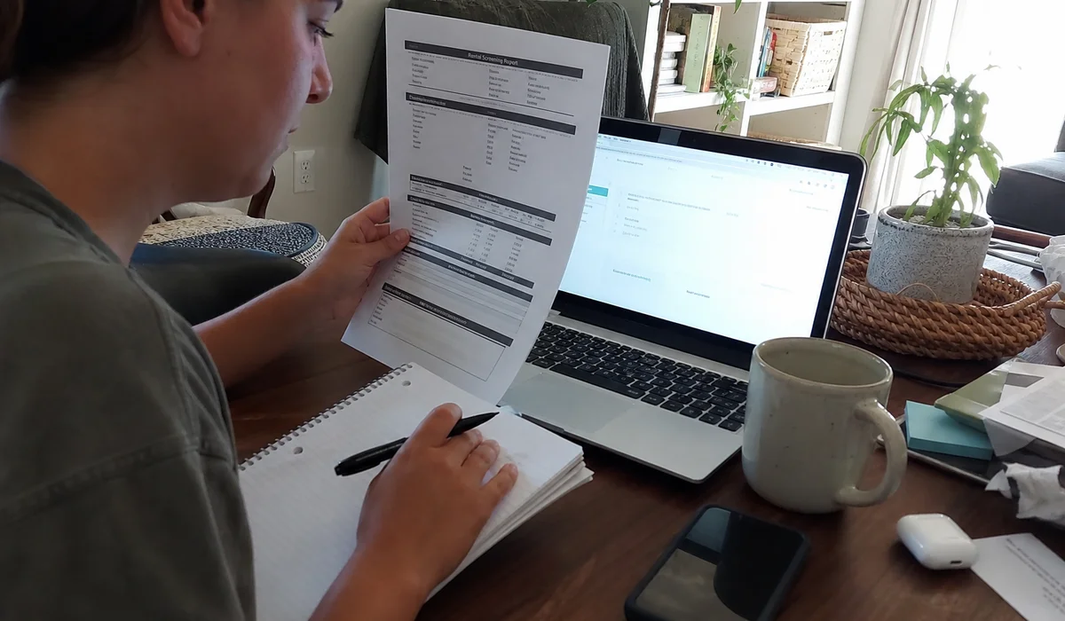 Renter taking notes on a rental screening report